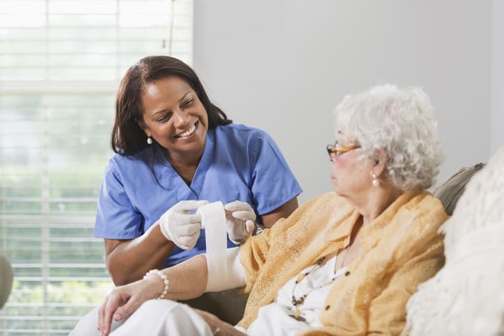 Caregiver assisting patient with wound care
