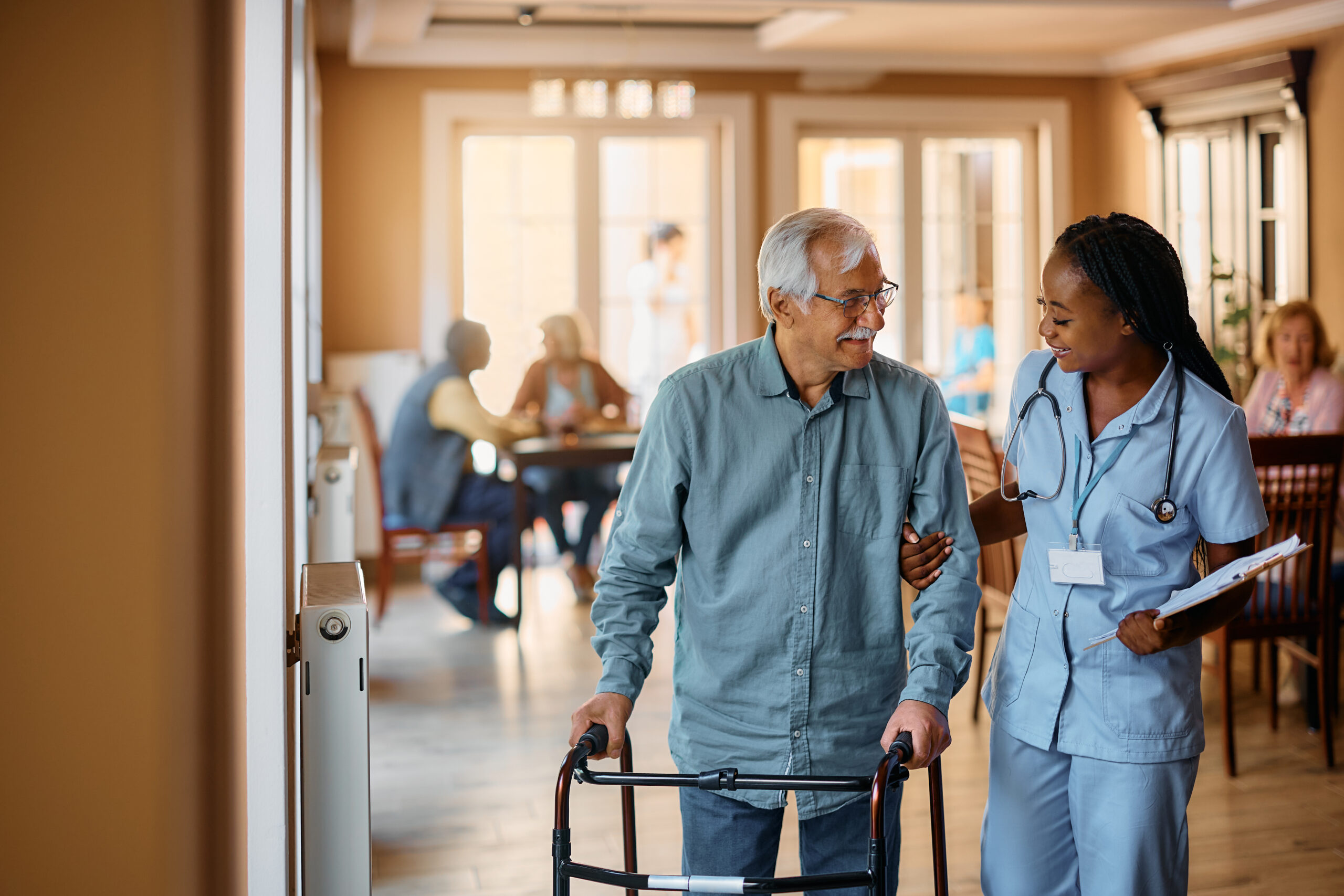 Caregiver assisting resident with walker